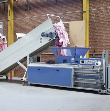 Textielverdichting bij NewRetex met een horizontale balenpers